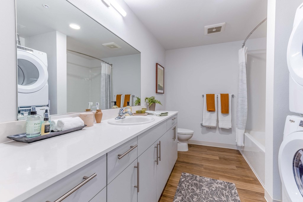 a white bathroom with a washer and dryer and a sink and a toilet at Riverfront Everett, Washington, 98101
