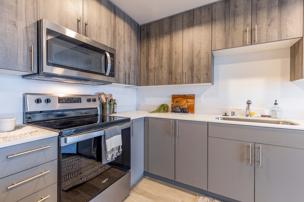 a kitchen with stainless steel appliances and gray cabinets at Riverfront Everett, Everett, WA