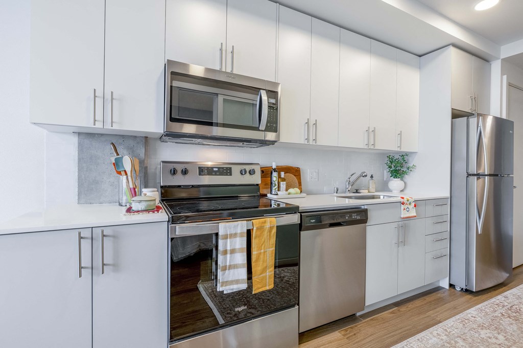 a kitchen with stainless steel appliances and white cabinets at Riverfront Everett, Washington