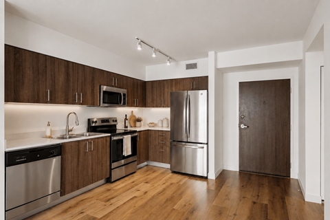 A kitchen with wooden cabinets and stainless steel appliances.
