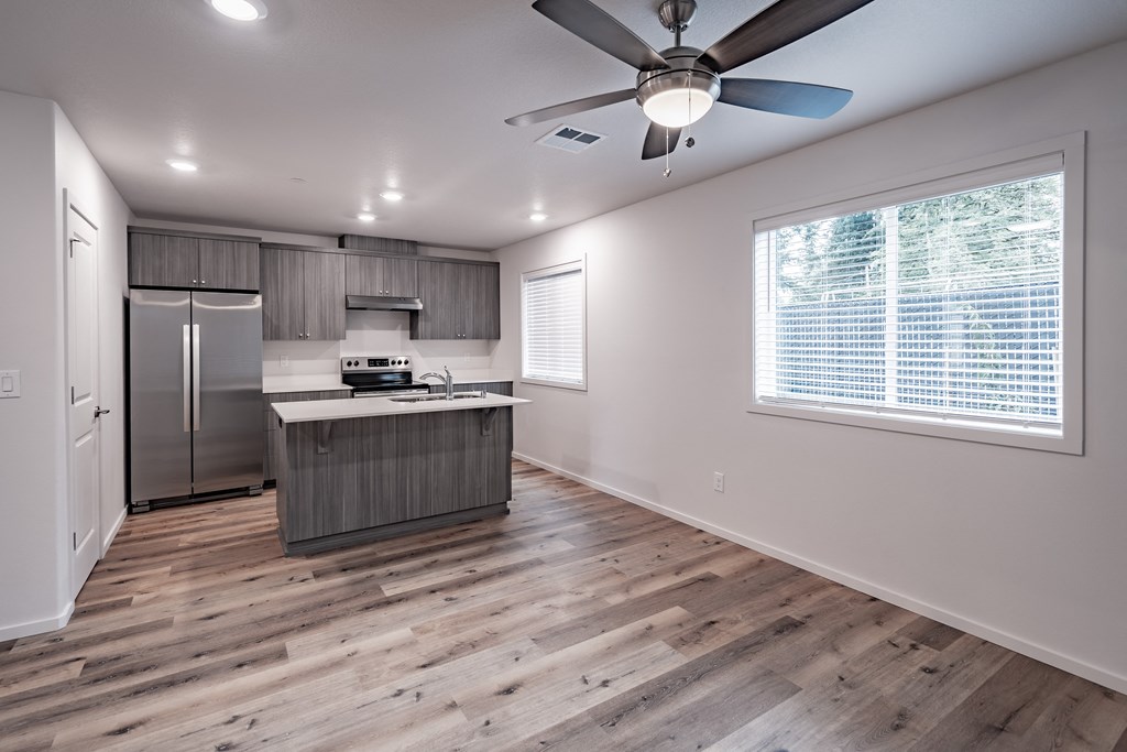 a kitchen with a large window and a ceiling fan