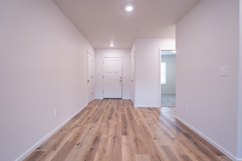 a living room with white walls and wood floors