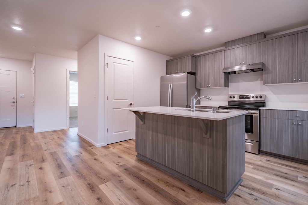 a kitchen with white walls and a wooden floor