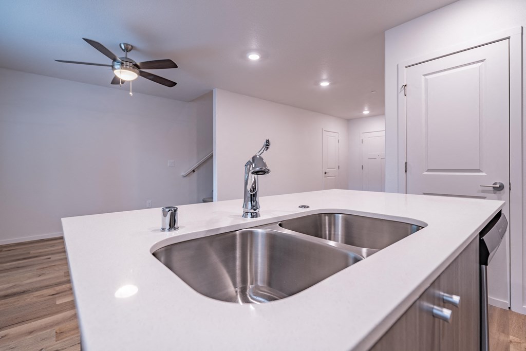 a kitchen with a sink and a ceiling fan