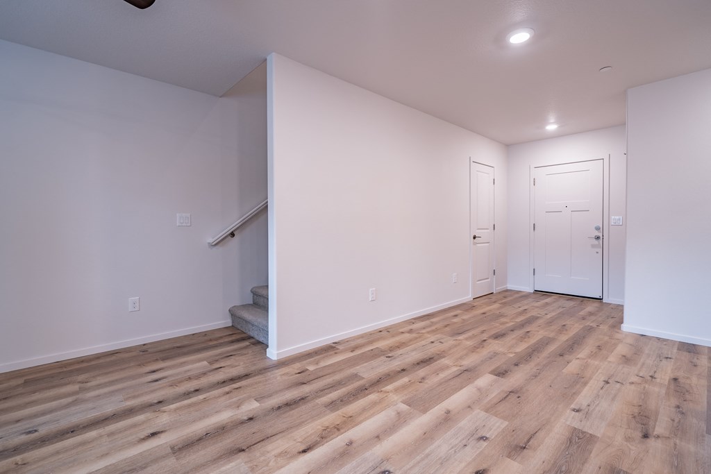 a living room with hardwood floors and white walls