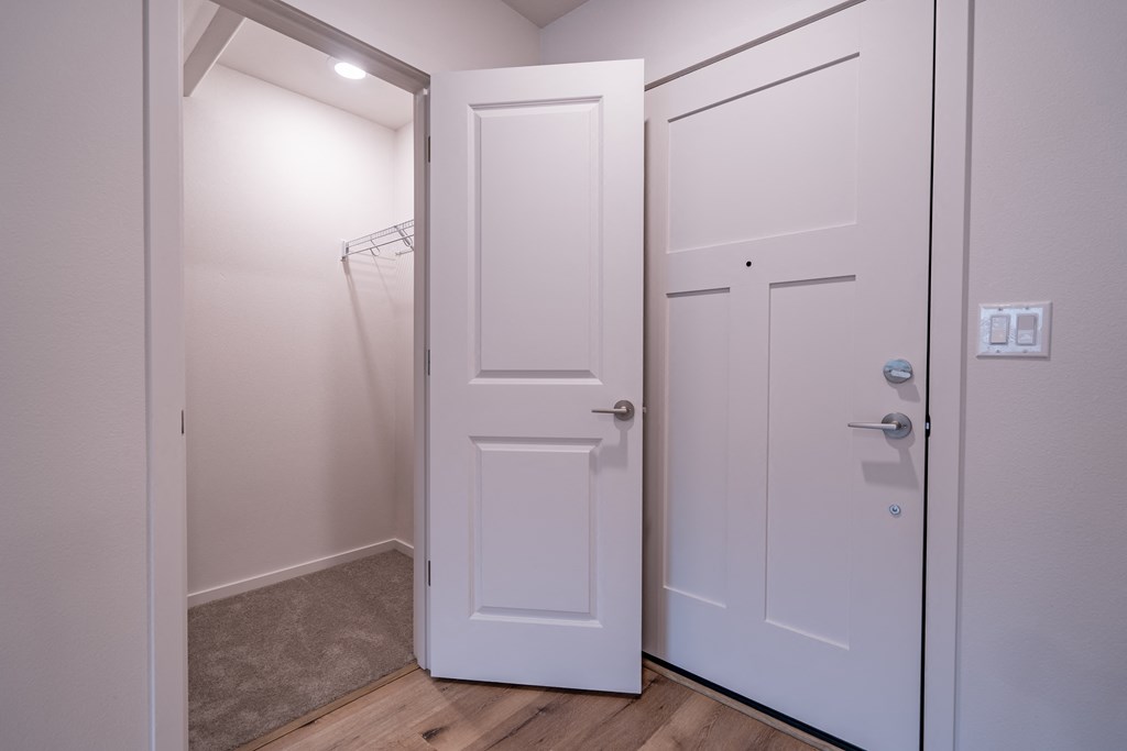 a small closet with a white door and a gray carpet