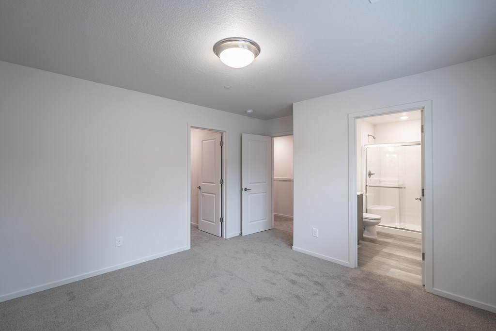 a bedroom with grey carpet and white walls