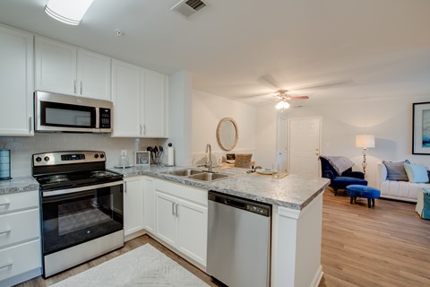 A modern kitchen with white cabinets and stainless steel appliances.