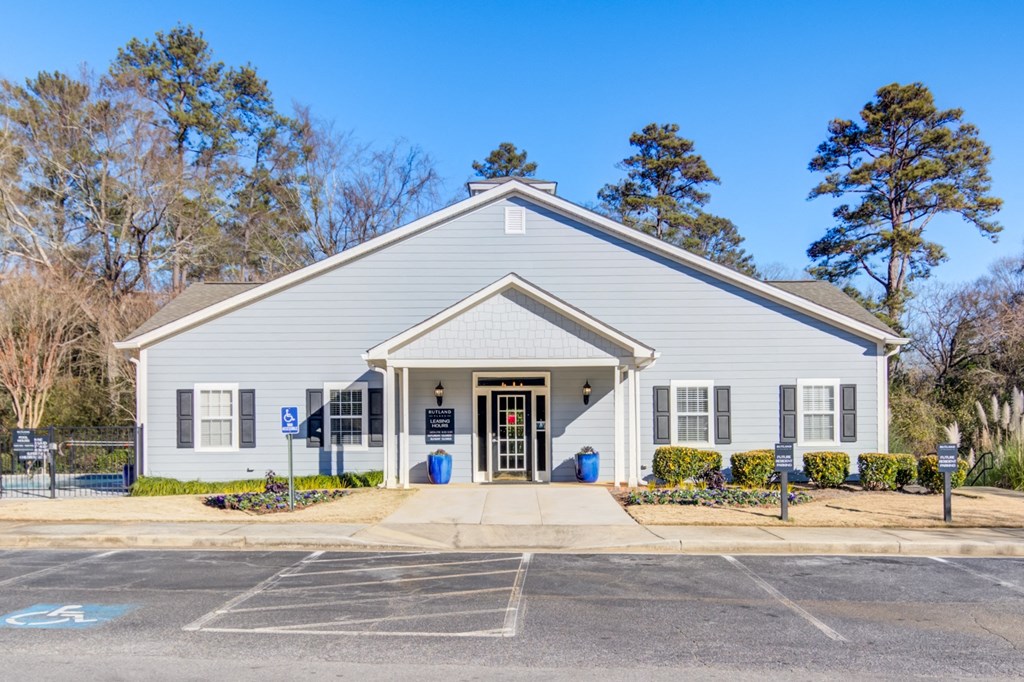 the front of a white church building with a sidewalk and parking lot