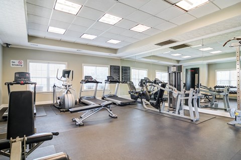 Modern fitness center at Rutland Place Apartment Homes in Macon, GA featuring cardio equipment, strength training machines, and free weights.