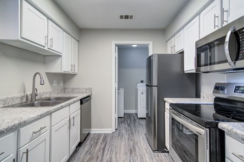 a kitchen with stainless steel appliances and white cabinets