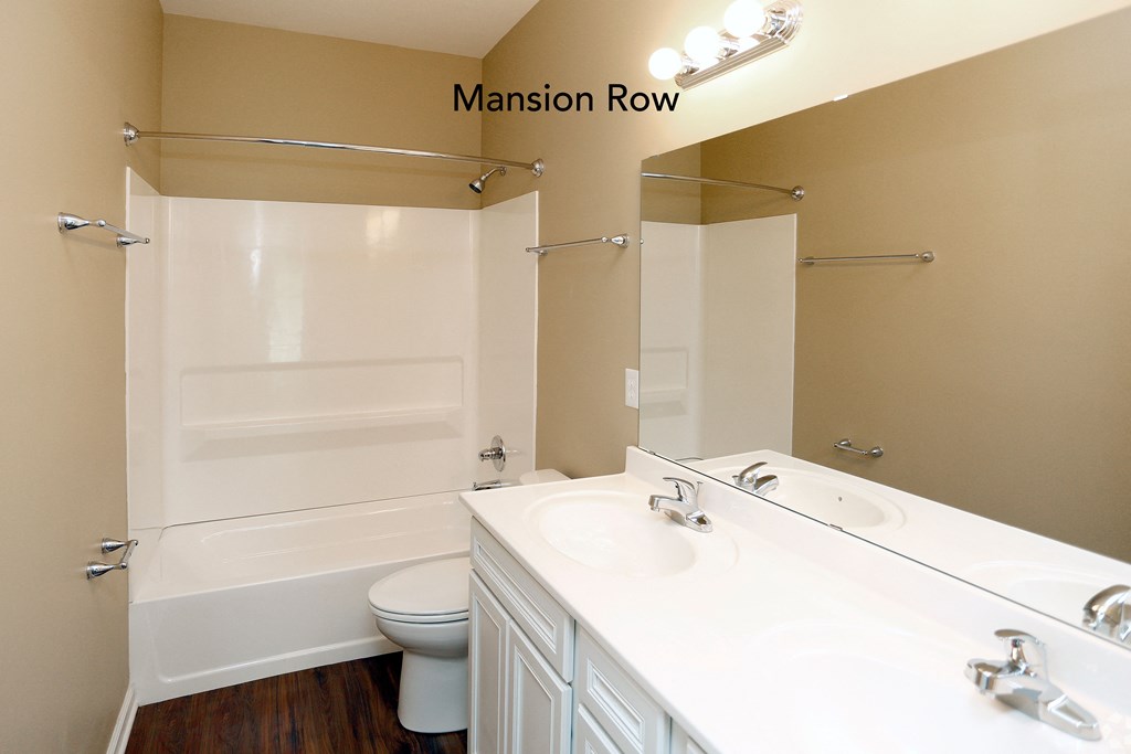 a bathroom with a white sink and toilet and a white bathtub with a shower curtain