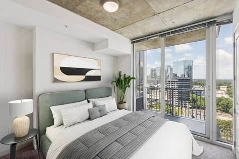 A bedroom with a large bed and a view of the city.