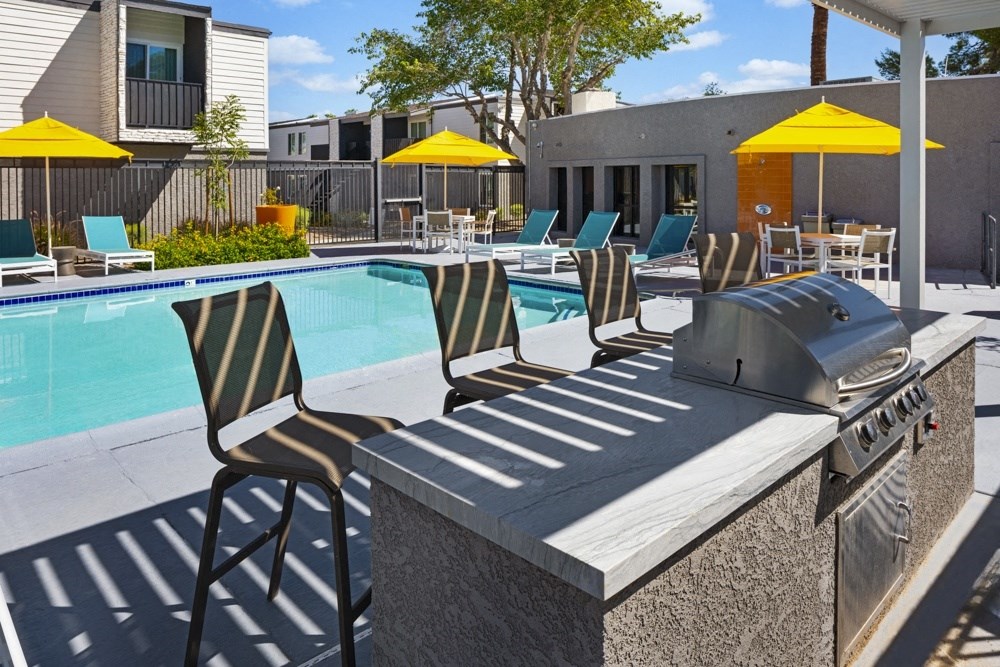 our apartments have a pool and a bar with chairs and a grill