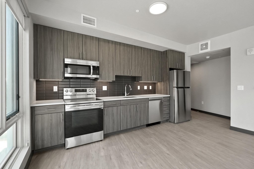 a kitchen with wooden cabinets and stainless steel appliances