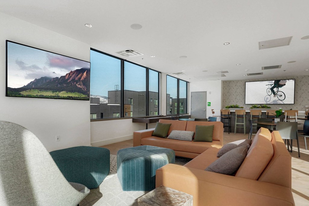a living room with couches and chairs and a large screen tv on the wall