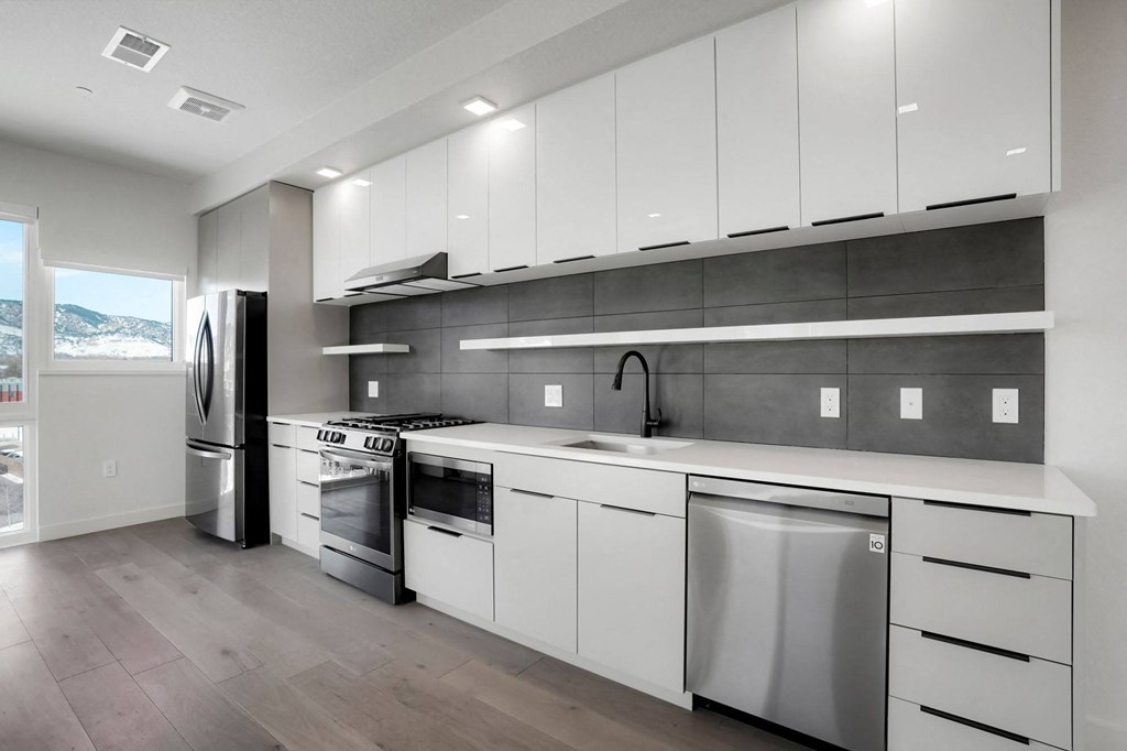 a kitchen with white cabinets and stainless steel appliances
