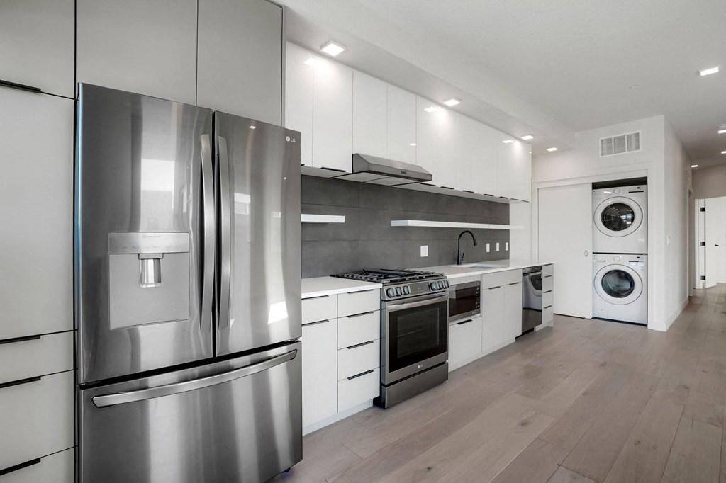 a kitchen with white cabinetry and stainless steel appliances