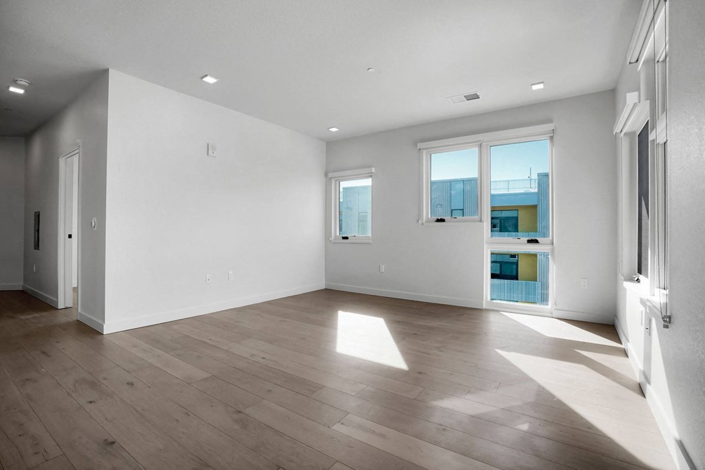 a bedroom with hardwood floors and white walls