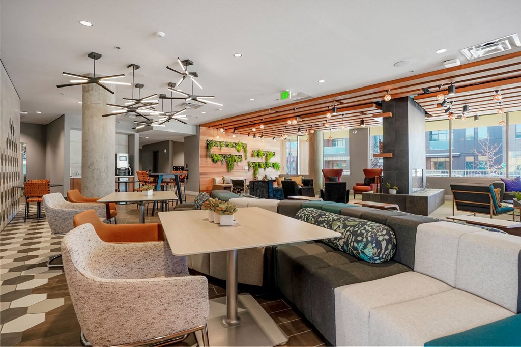 a seating area with couches tables and chairs and a chandelier