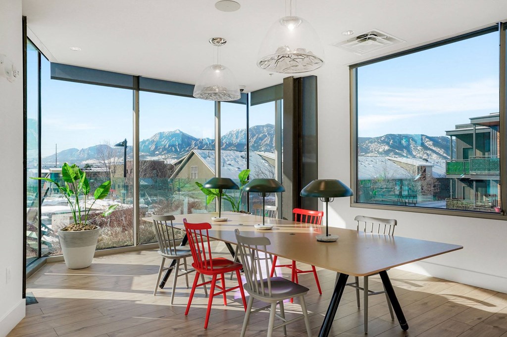 a dining room with a table and chairs with a view of the mountains in the distance