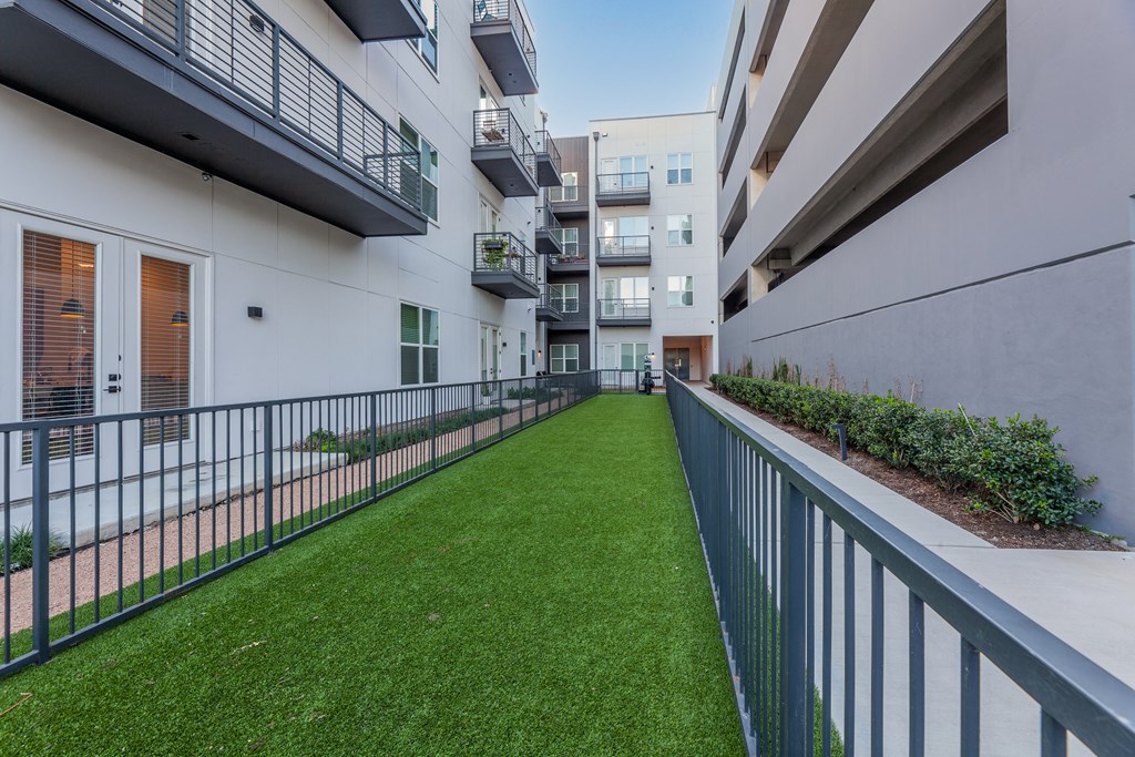 a grassy area on the balcony of an apartment building