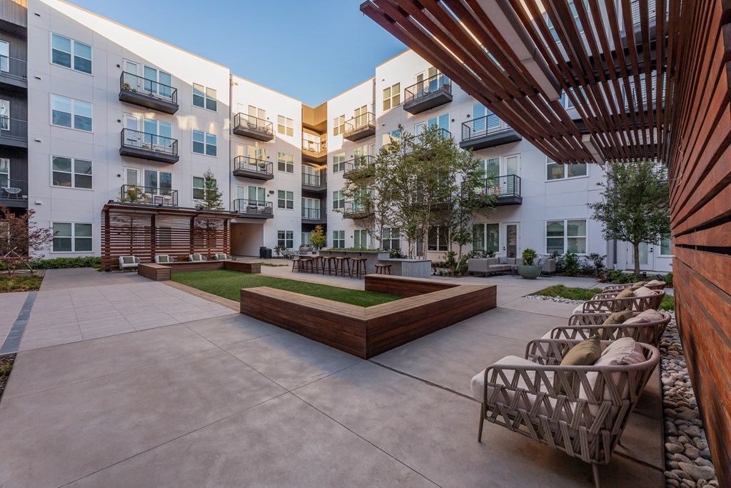Apartments for Rent in Downtown Dallas, TX - 4600 Ross - Modern Courtyard with Comfortable Seating Options, a Grilling Station, and Beautiful Landscaping