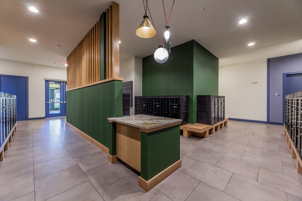 a large room with a table and benches in front of a green wall
