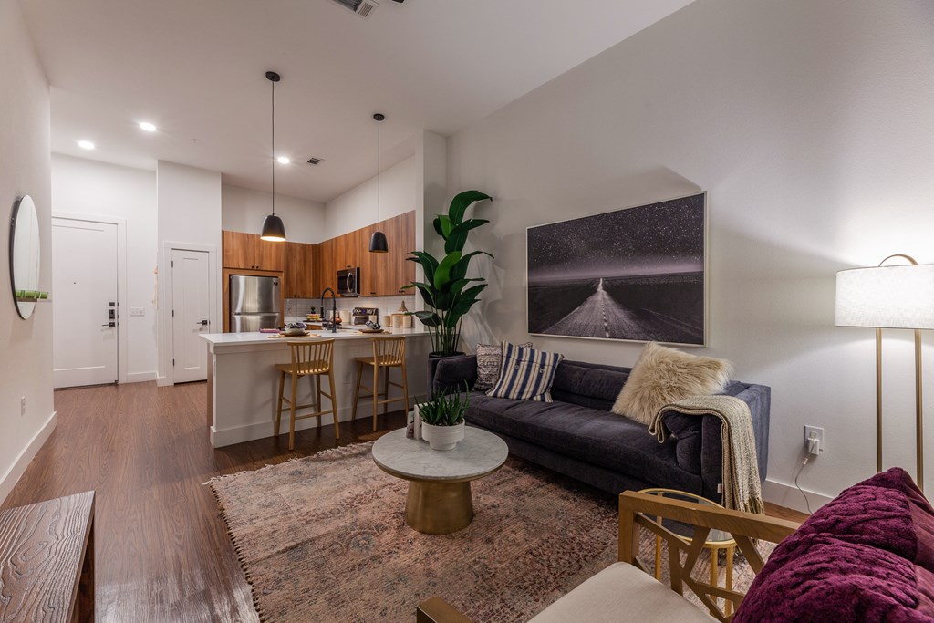 Dog-Friendly Apartments in Old East Dallas, TX - 4600 Ross - Living Room with Hardwood-Style Flooring, Modern Light Fixtures, and Open-Concept Layout with Kitchen