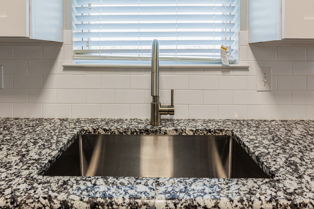 a kitchen sink with a window in the background