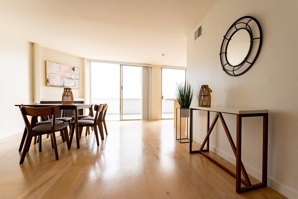 a dining room with a table and chairs and a clock on the wall