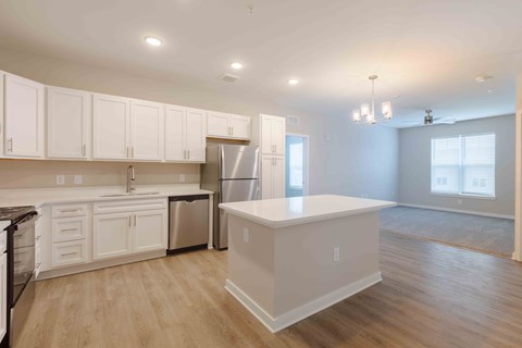 A kitchen with white cabinets and a white island.