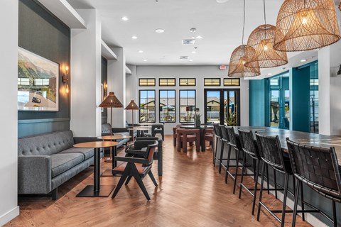 A modern dining area with wooden floors and black chairs.