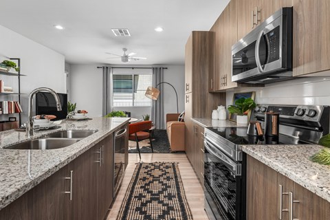 A modern kitchen with wooden cabinets and a marble countertop.