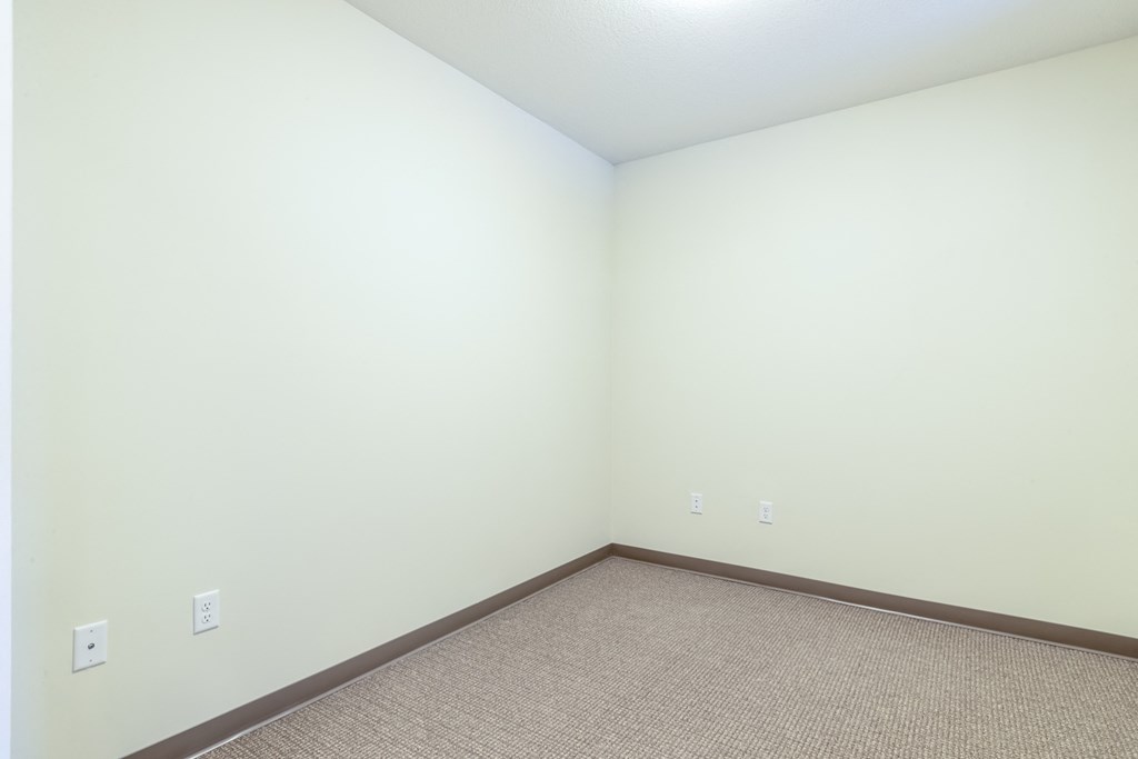 an empty room with white walls and a carpet