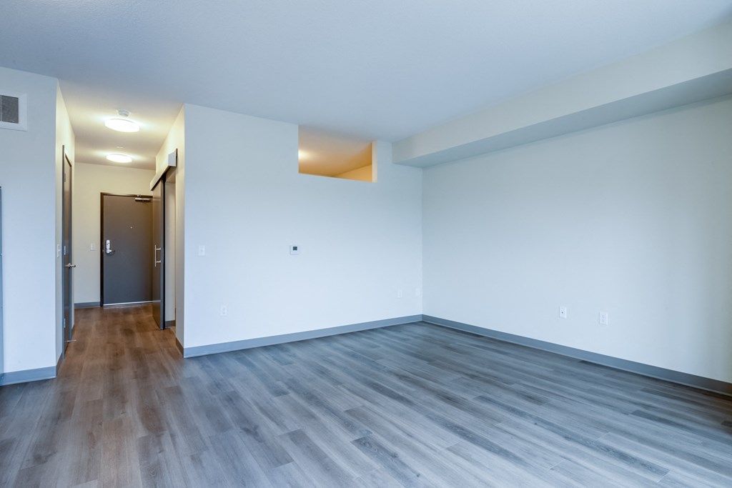 an empty living room with white walls and wood floors