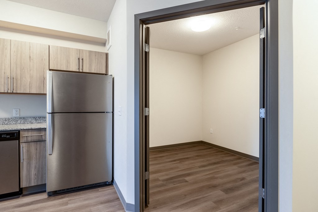 a kitchen and living room with a stainless steel refrigerator