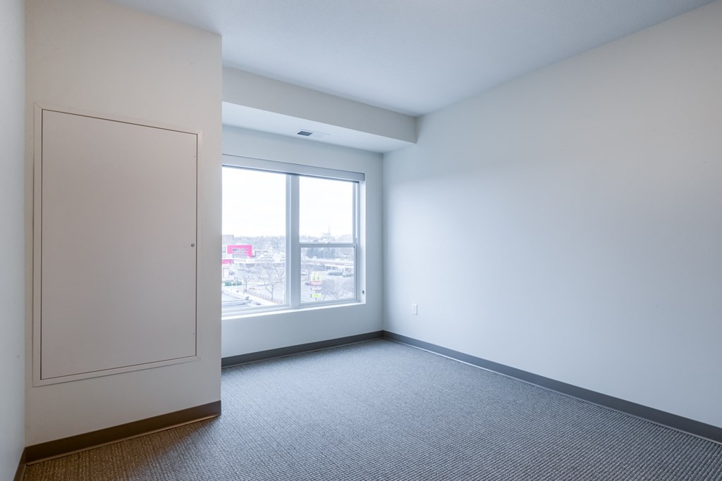 an empty room with a window and a door