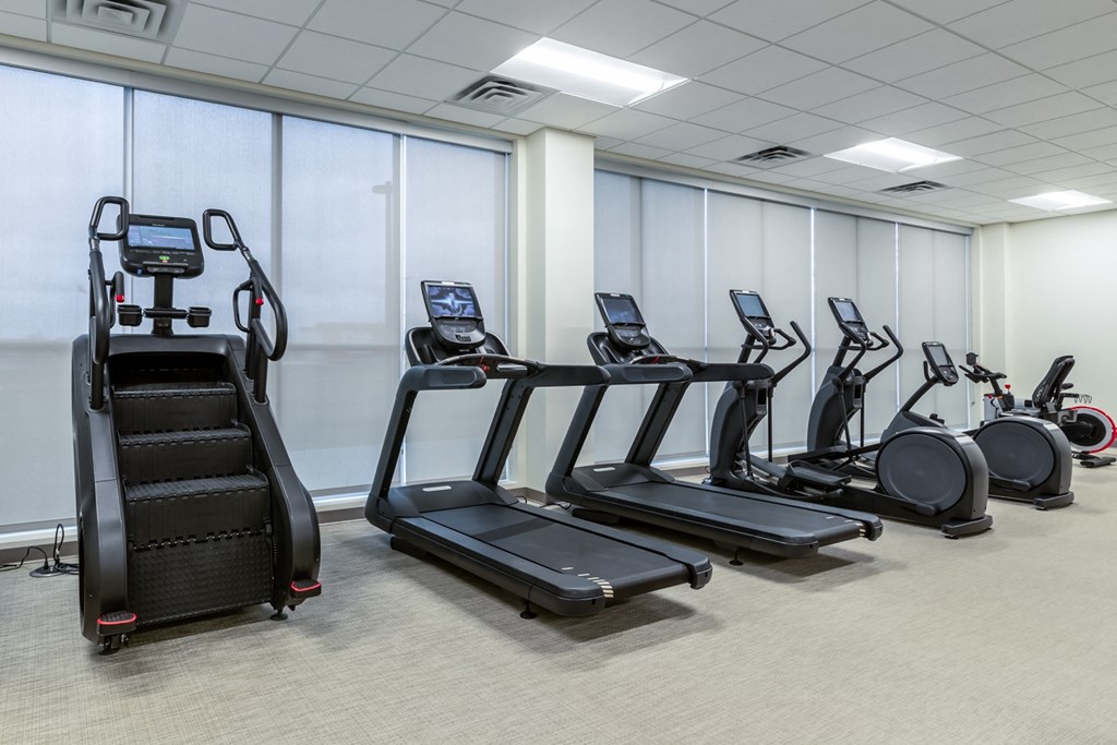 a gym with various cardio equipment and treadmills