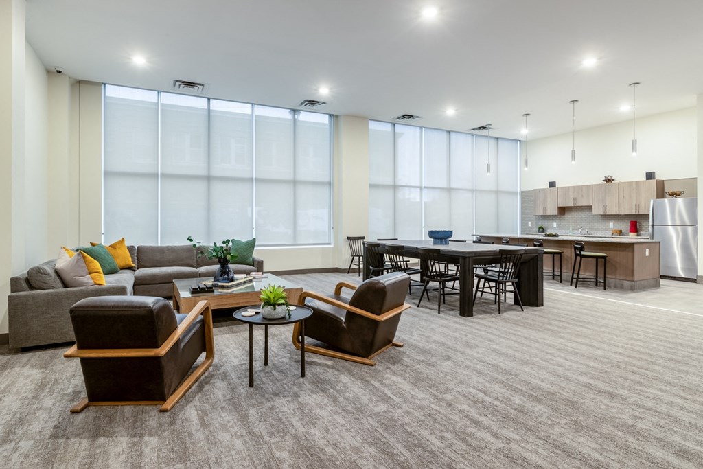 a living room with couches and chairs and a kitchen with a table and chairs