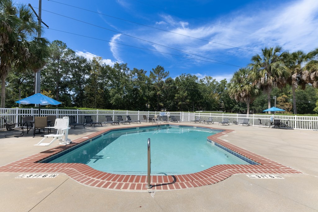 Resort-style pool with outdoor seating at Savannah Sound pet-friendly apartments in Tallahassee FL