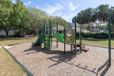 Outdoor playground with open space at Savannah Sound apartments in Tallahassee, FL