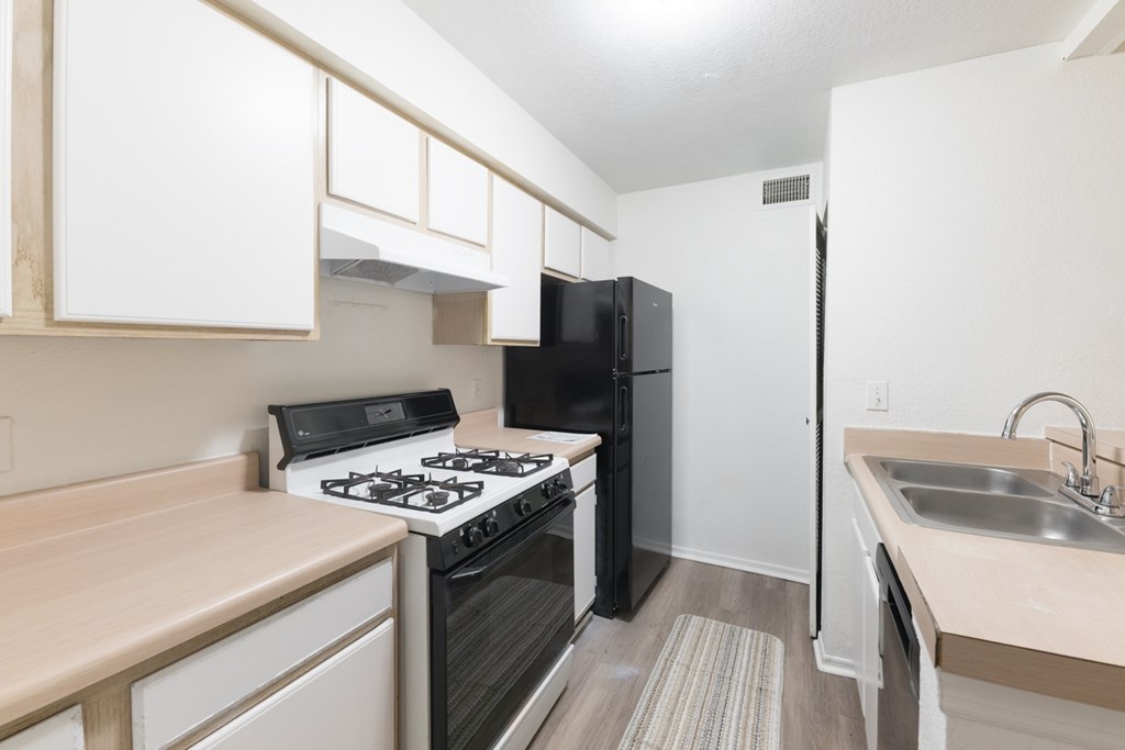 A kitchen with black appliances and white cabinets.