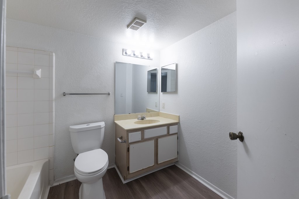 A white toilet sits next to a sink in a small bathroom.