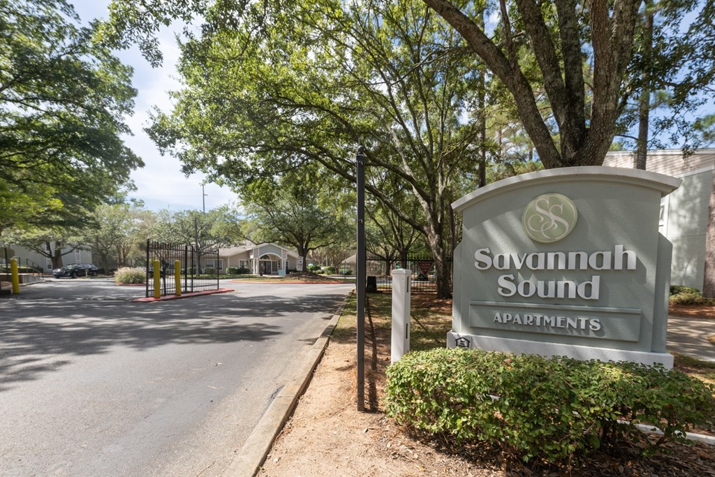 Savannah Sound Apartments sign in front of a tree.