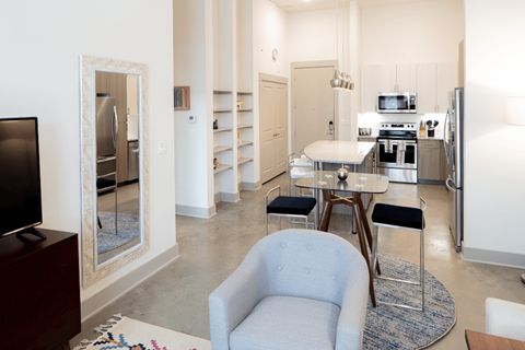 A modern kitchen with a blue chair in the middle of the room.
