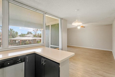 Kitchen view opening to living room with large windows and open layout at Sentry Tempe apartments in Tempe  a pet friendly community near Mesa, Arizona
