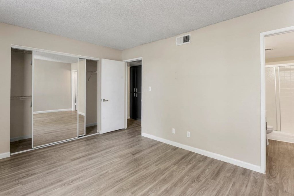 Bedroom with spacious closet featuring mirrored sliding doors at Sentry Tempe apartments in Tempe near Mesa, Arizona