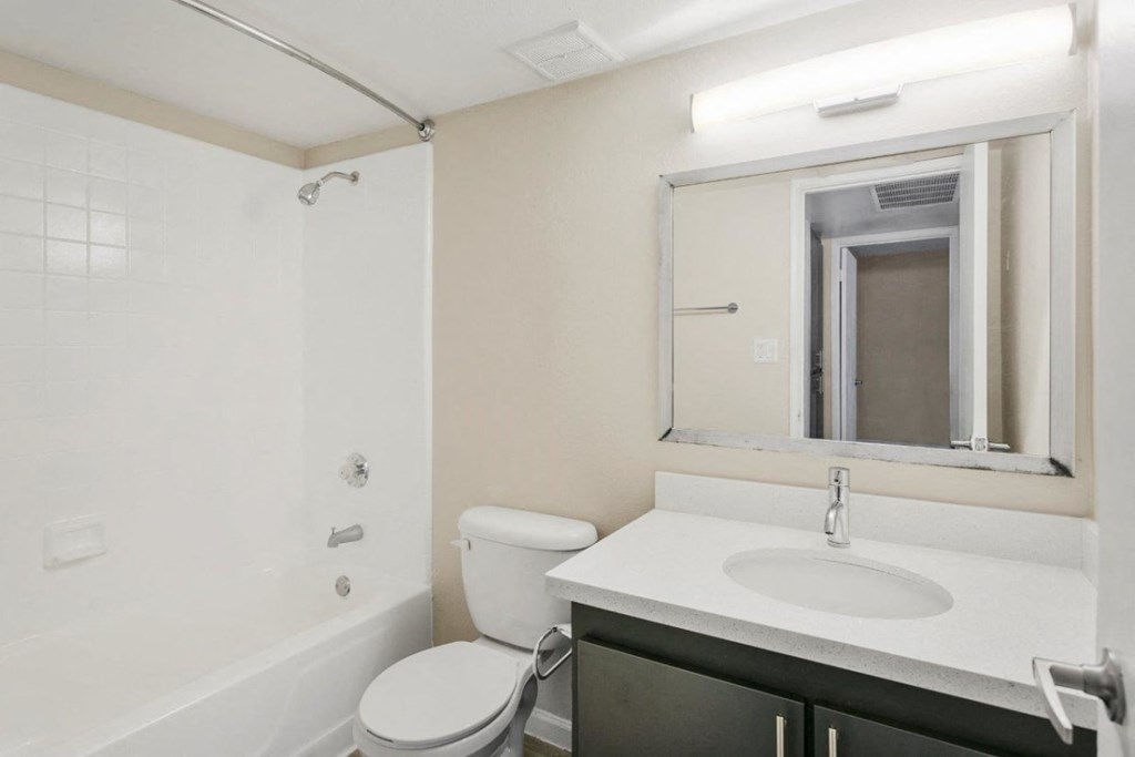 Bathroom with tub, shower, and large mirror at Sentry Tempe apartments in Tempe near Mesa, Arizona