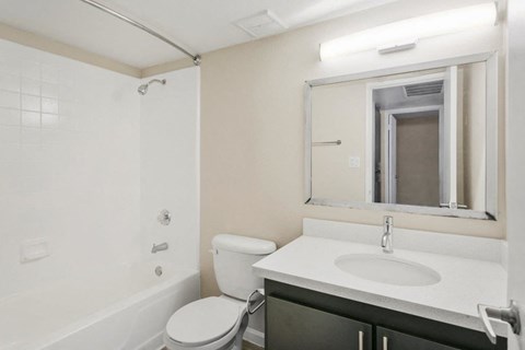 Bathroom with tub, shower, and large mirror at Sentry Tempe apartments in Tempe near Mesa, Arizona